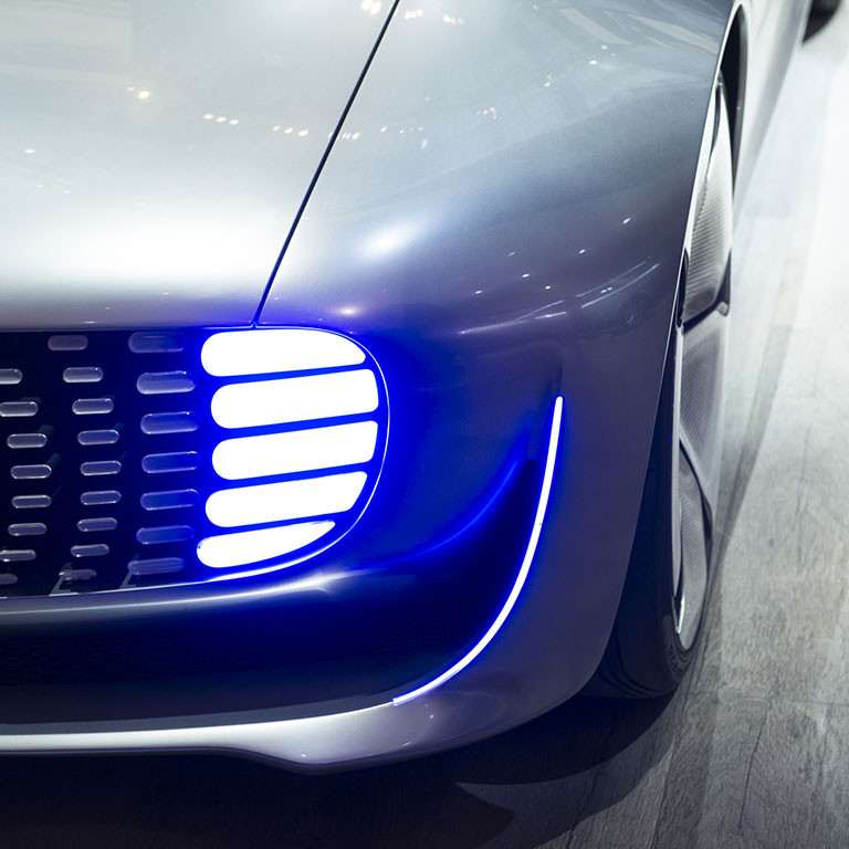 Silbernes Auto mit blau leuchtendem Scheinwerfer